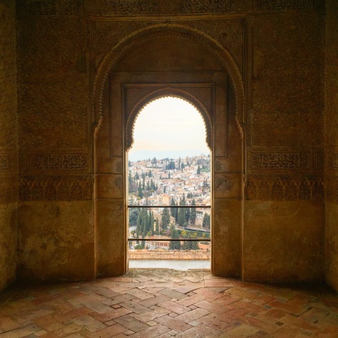 A typical Moorish arch overlooking overlooking the terracotta roofs of Granada far below.